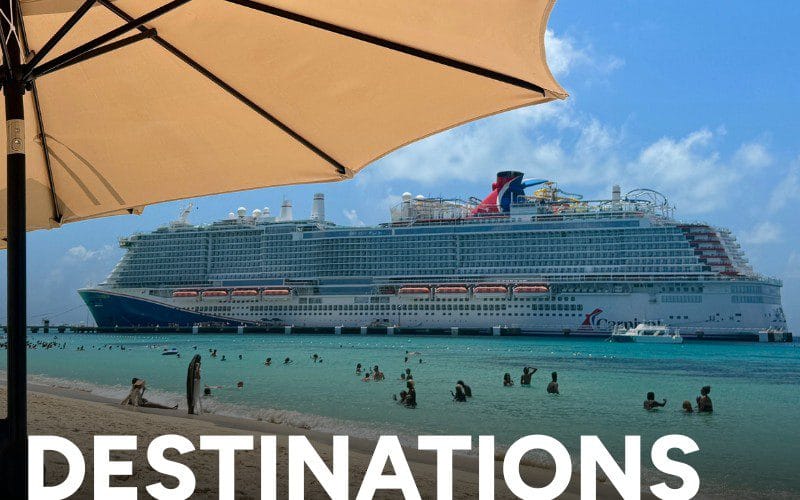 Carnival cruise ship anchored off a beach under a large umbrella.