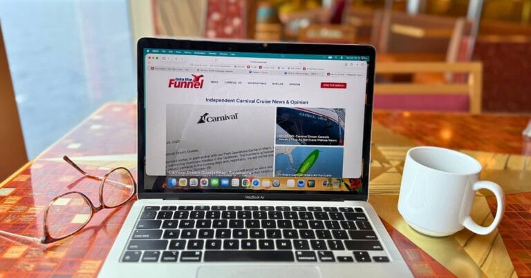 Solo cruise Workspace setup on Carnival Dream with laptop, coffee, and ocean view.